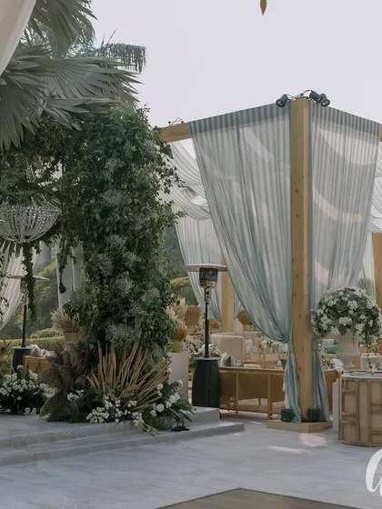 A view of the elegant tent structure, with its draped fabric and surrounding greenery. The design seamlessly integrates the indoor comfort with the beauty of the outdoor setting.