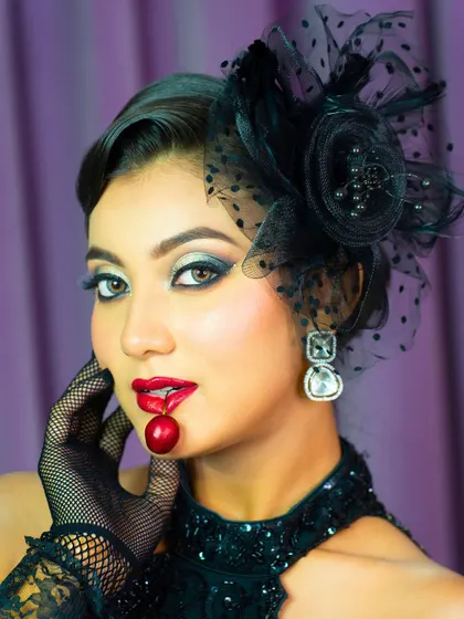 A playful and creative shot with a cherry. This shows how makeup can be part of a larger artistic concept, a skill useful for campaign shoots.