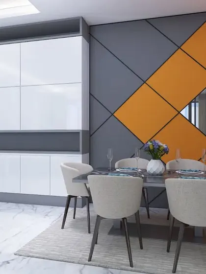 The dining area features a bold accent wall with a geometric pattern in orange and grey, adding a pop of color.