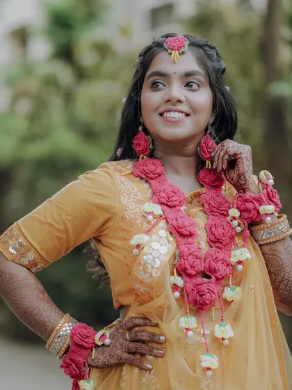 The bride looking away with a smile, showcasing her floral jewellery.