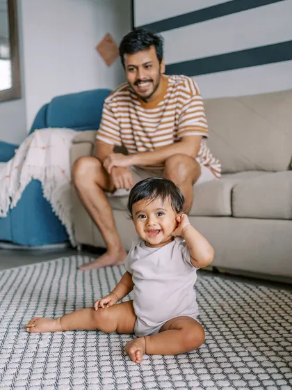 A father and son playing on the floor. The baby's happy expression is priceless.