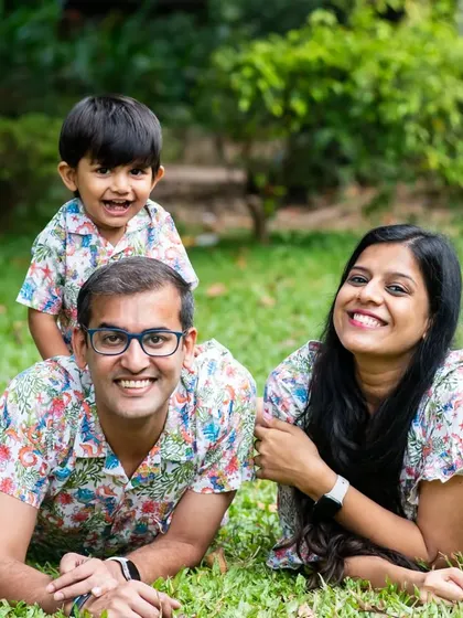 A fun and happy family portrait taken during a pre-birthday outdoor shoot. The matching floral shirts and the genuine smiles make this a joyful and vibrant photo.