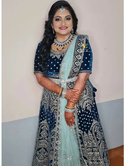 A full-length shot of Akshatha in her magnificent blue reception lehenga, looking every bit the part of a glamorous bride.