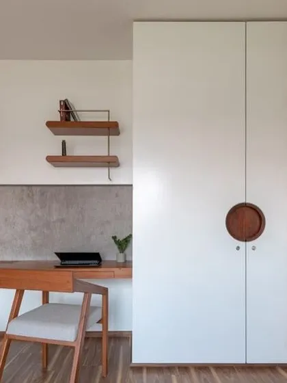 This wardrobe design features a unique circular wooden handle and a decorative tile strip that adds a pop of color and personality to the otherwise minimalist white doors.