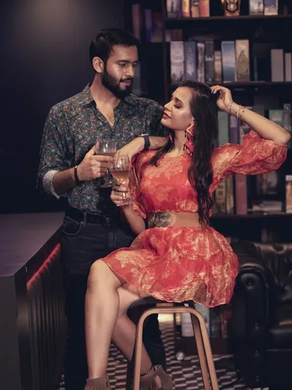 A chic and stylish shot of a couple enjoying a drink at a bar setup, perfect for a modern and sophisticated pre-wedding theme.