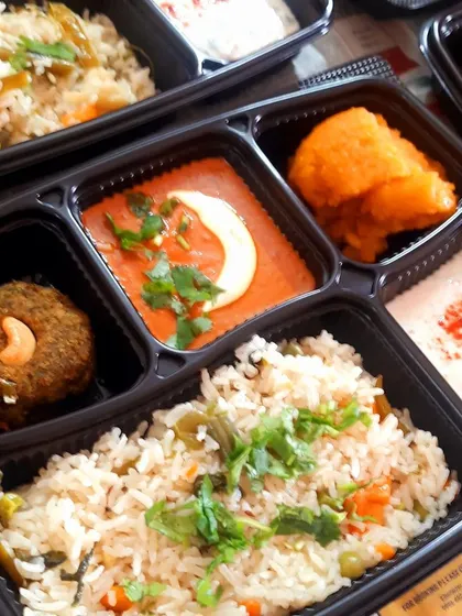 A well-balanced meal box perfect for any gathering. This one includes flavorful veg biryani, creamy paneer butter masala, a healthy hara bhara kebab, and raita, offering a complete and satisfying meal.