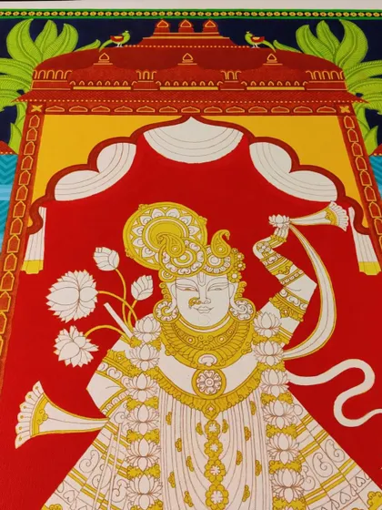 The Srinathji painting with the first layers of color, showing the vibrant red and yellow.