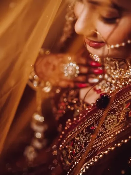 A bride's portrait is a story in itself. Here, we used soft, warm lighting and the delicate veil to create an intimate and serene mood. We focus on capturing the quiet anticipation and the intricate details of the bridal attire and jewelry.