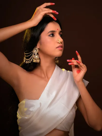 A beautiful and serene ethnic portrait. The model's traditional jewelry and gentle expression are highlighted by warm, soft lighting.