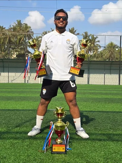 Another shot of our coach celebrating with the trophies. Their dedication is a huge part of our academy's success.