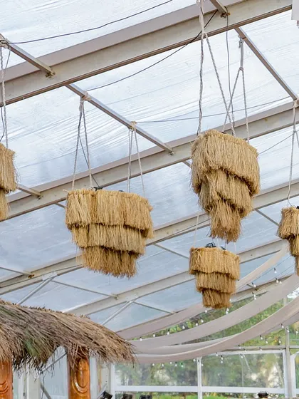Chandeliers made of tiered straw hang from the ceiling, a brilliant example of using natural materials to create luxurious and thematic lighting fixtures.