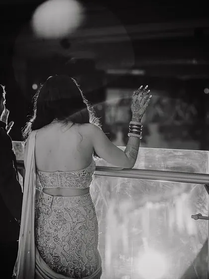 A quiet, cinematic moment of the couple taking a break from the party, looking out at the city lights.