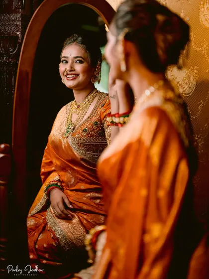 A beautiful reflection shot, with the bride smiling at herself in an ornate mirror.