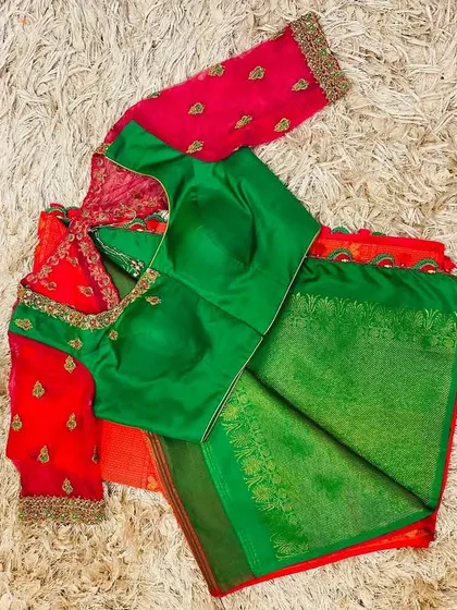 A classic green and pink combination. This green silk blouse features pink net sleeves with hand embroidery.