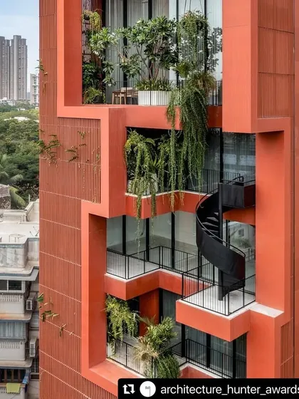 A detail of the Sarvasva tower's facade, showing how we integrate planters and cascading greenery directly into the architecture. A sculptural black spiral staircase connects the terraces, encouraging movement through these elevated gardens.