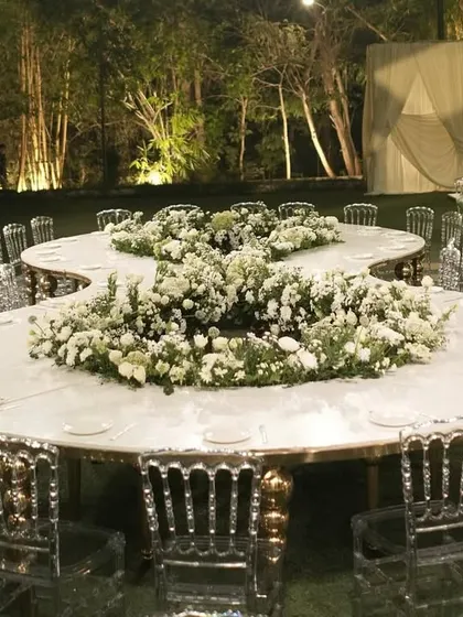 The stunning figure-eight floral table, surrounded by clear Napoleon chairs.