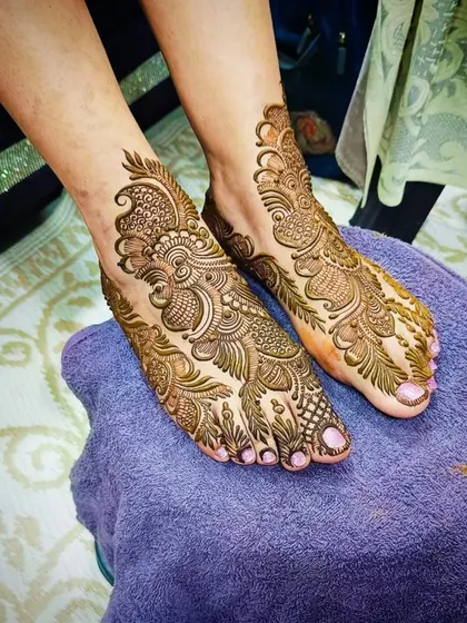 An angled view of the intricate paisley foot mehandi.