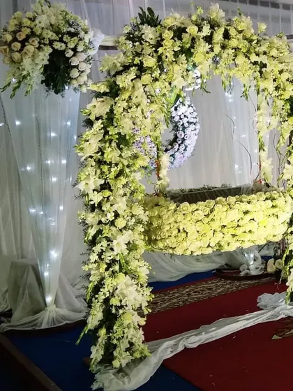 A beautiful cradle, or 'thottilu', completely covered in white flowers. This creates a pure and serene space for the baby during the naming ceremony.