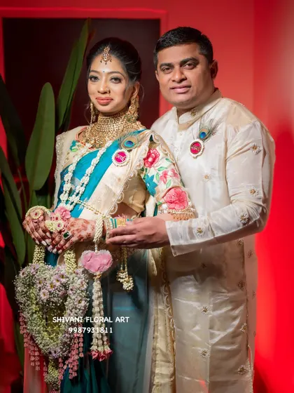 This happy couple is celebrating their baby shower, and the mom-to-be is holding a custom heart-shaped floral hand prop I created for their photoshoot.