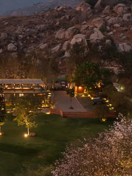 As dusk settles, 'The Earth' project integrates into the rocky terrain of the Nandi Hills. Our landscape lighting design is intentionally soft, tracing pathways and uplighting trees to create a gentle glow that respects the darkness of the natural environment.