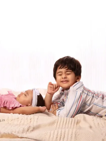 A sweet, peaceful moment between a sleeping baby sister and her watchful older brother.