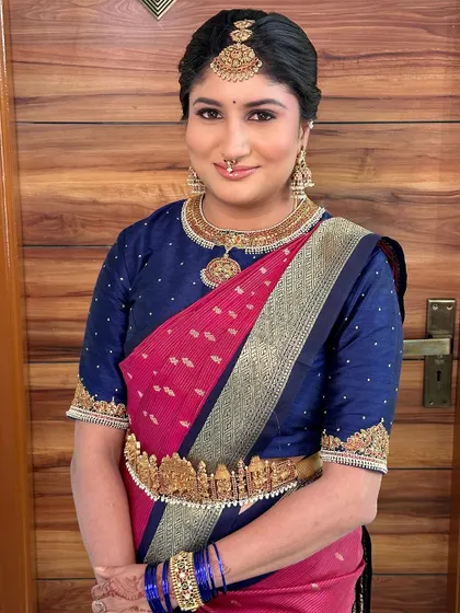 A close-up of the bride's makeup, featuring a soft eye look and a glowing complexion that complements her temple jewellery.