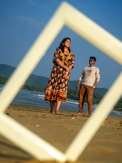 Getting creative with a pre-wedding shoot on a Goa beach. Using a simple white frame, I created a unique composition that draws the eye directly to the couple against the stunning backdrop of the sea and hills. I love finding artistic ways to make your photos stand out.