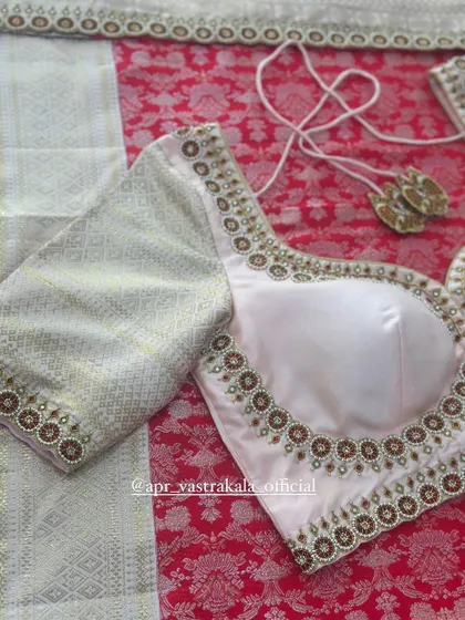 An off-white blouse with a simple but elegant embroidered neckline.