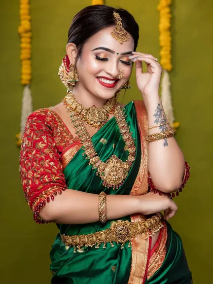 The happiness of a bride is infectious. For her muhurtham, we chose a grand temple jewellery set with intricate carvings, which looked absolutely regal with her green and red silk saree.