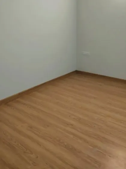 This room showcases a cool, light grey wall colour paired with a wooden floor. This combination creates a modern and calming atmosphere, suitable for a bedroom or study.