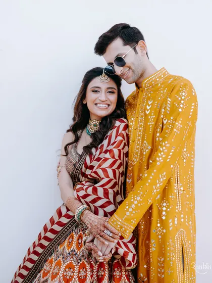 A happy and relaxed portrait of the couple, with the bride holding onto the groom's arm, showcasing their easy connection.