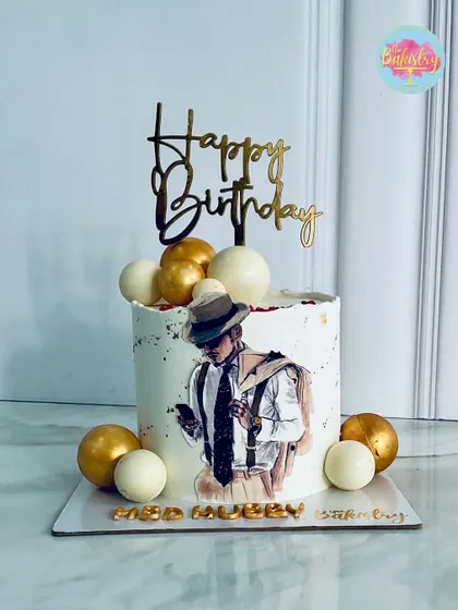 A stylish cake for a "fab hubby," featuring a hand-drawn portrait and elegant gold and white spheres.