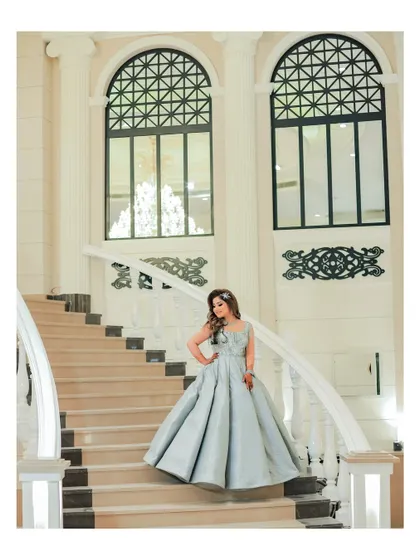 A solo portrait of the bride on the grand staircase, looking like a princess in her magnificent silver ball gown.