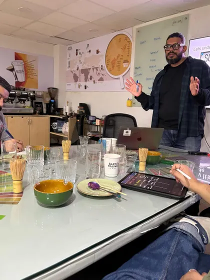 A trainer leading a Matcha Masterclass, explaining the nuances of this unique beverage to an engaged group of students.