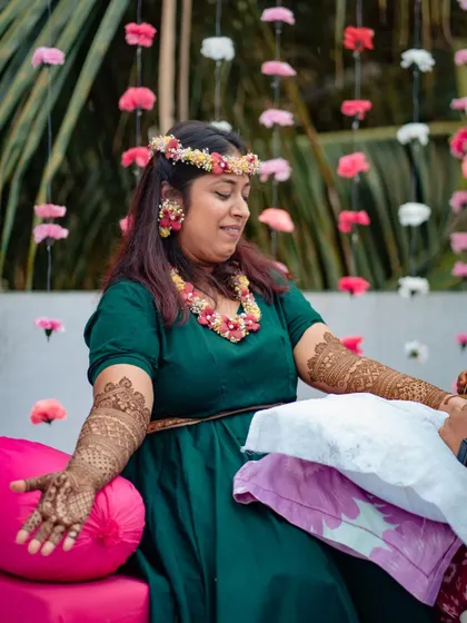 A bride enjoying a quiet moment during her mehndi application.