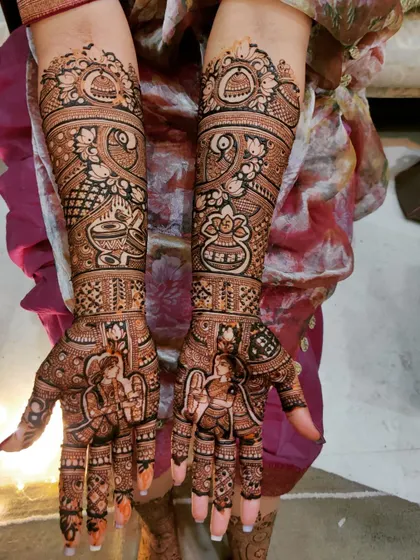 This design is rich with auspicious symbols for a wedding, including kalash pots and lotus flowers, alongside portraits of the bride and groom.