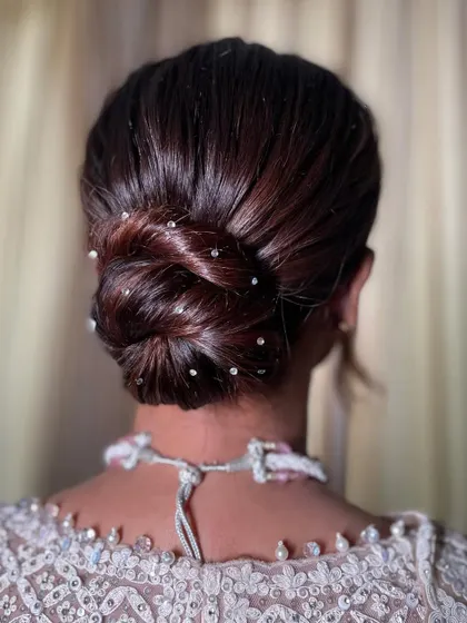 I call this the Swarovski knot. It's a sleek, twisted bun that I decorated with tiny Swarovski crystals for a touch of sparkle. It’s a subtle but very glamorous detail.