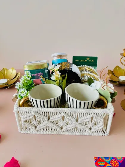 The combination of the natural macrame texture with the modern striped cups and gold accents creates a unique and stylish gift.