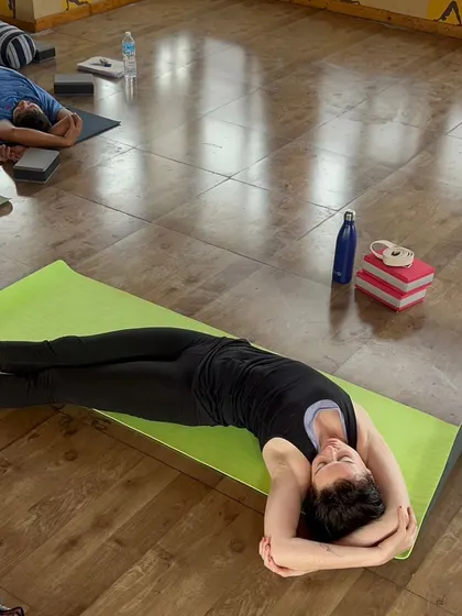 A student rests in a supported side-lying pose, a common sight in our deeply relaxing Yin and Restorative classes.