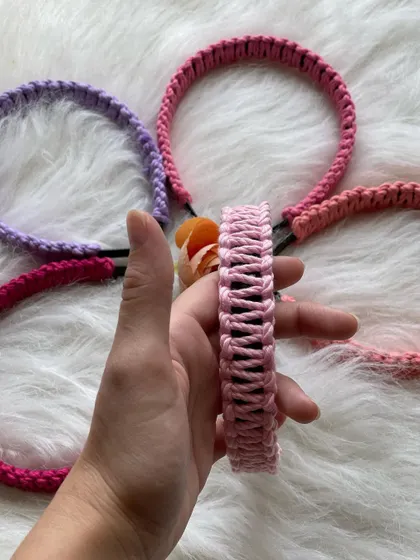 Showcasing a light pink macrame hairband to give you a better sense of its width and craftsmanship. In the background, you can see other color options available in my collection.