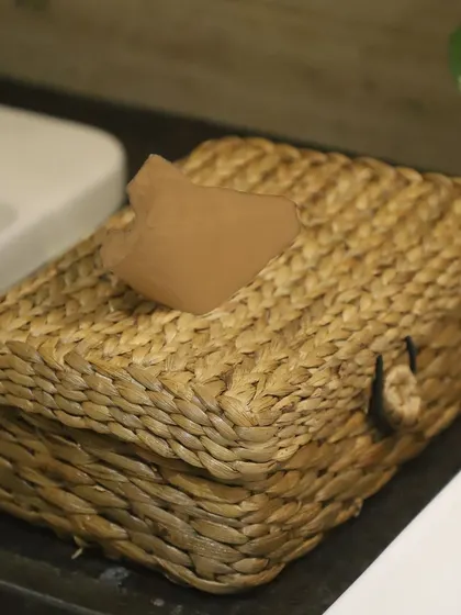 A close-up of our woven tissue box in a bathroom setting. This functional decor piece is crafted from natural fibers, offering an eco-friendly and stylish alternative to cardboard or plastic dispensers.