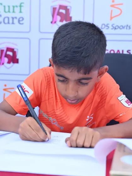 Prahlad Pillai puts pen to paper, signing his academy contract. This is a significant milestone where I formalize my commitment to developing a young player's potential.