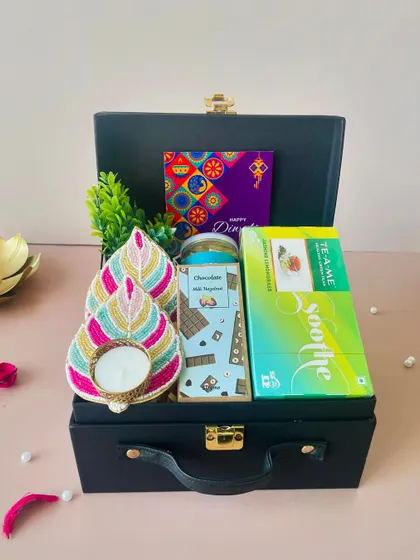 This hamper shows how we combine utility and festivity, with items like tea and snacks paired with a beautiful decorative t-light holder.