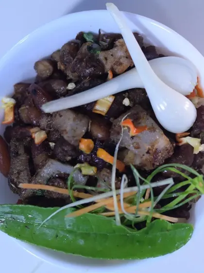 My Naga-style pork cooked with kidney beans, a traditional and filling combination. The dish is garnished with fresh herbs and spring onions for extra flavor.