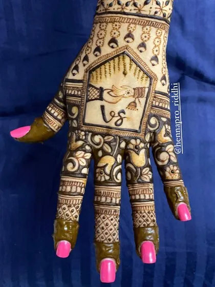 A lovely back-hand design for a bride. This piece includes the couple's initials, a "hath-bandhan" motif, and hanging kaliras for a look that is both personal and traditional.