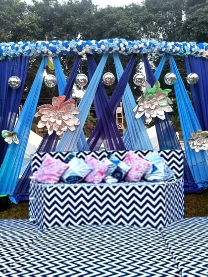 A chic and modern Sangeet stage with a blue and white theme. The chevron-patterned seating and flooring, combined with blue draping and silver accents, create a stylish and contemporary look.