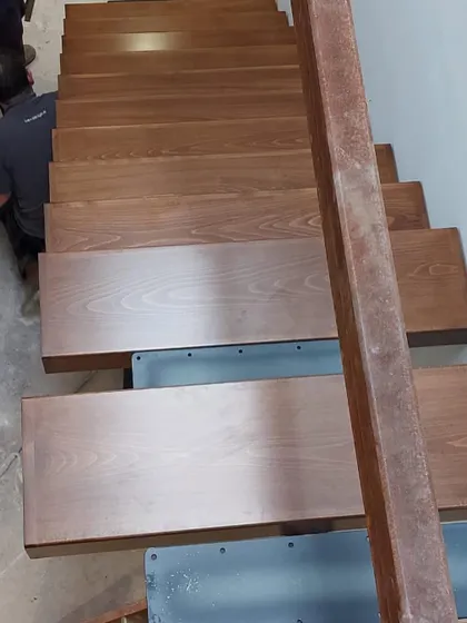 An overhead view during the installation process, showing the precise alignment of the oak treads on the central steel beam.