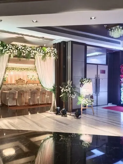 A glimpse into a special wedding event at Ramada Navi Mumbai. The view shows the elegant entrance leading to the main stage, with a beautiful floral photo wall on the side for guests.