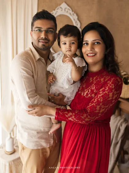 A lovely lifestyle family portrait. The family's coordinated outfits and happy expressions create a warm and inviting image in a bright, natural setting.