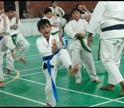 A young student's powerful kiai and determined expression during his belt exam performance.